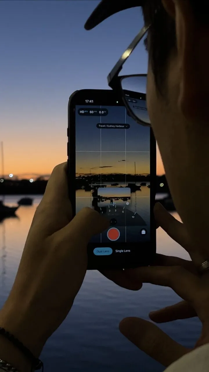 Creator recording a golden-hour waterside video on iPhone with ContentCam